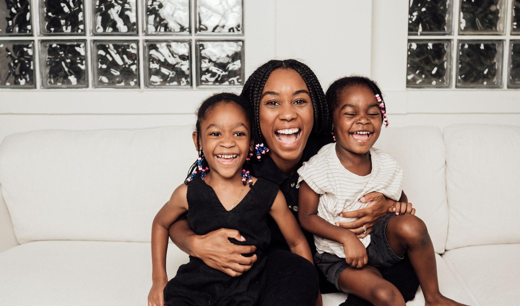 a woman sitting on a couch with two kids