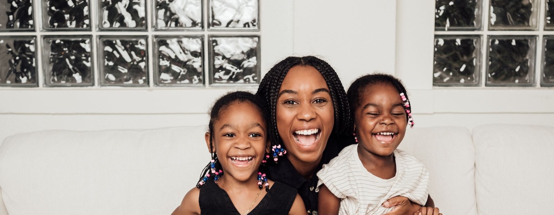 a woman sitting on a couch with two kids