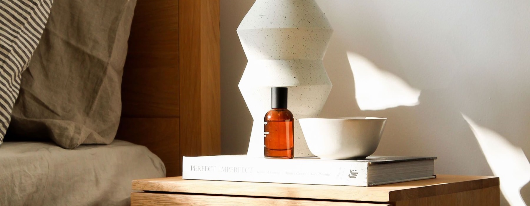 a vase with cotton stems on a bedside table